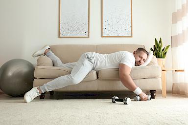 Mann mit Hanteln schlafend auf Sofa
