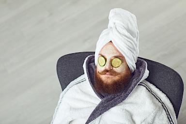 Mann im Bademantel mit Gurkenmaske